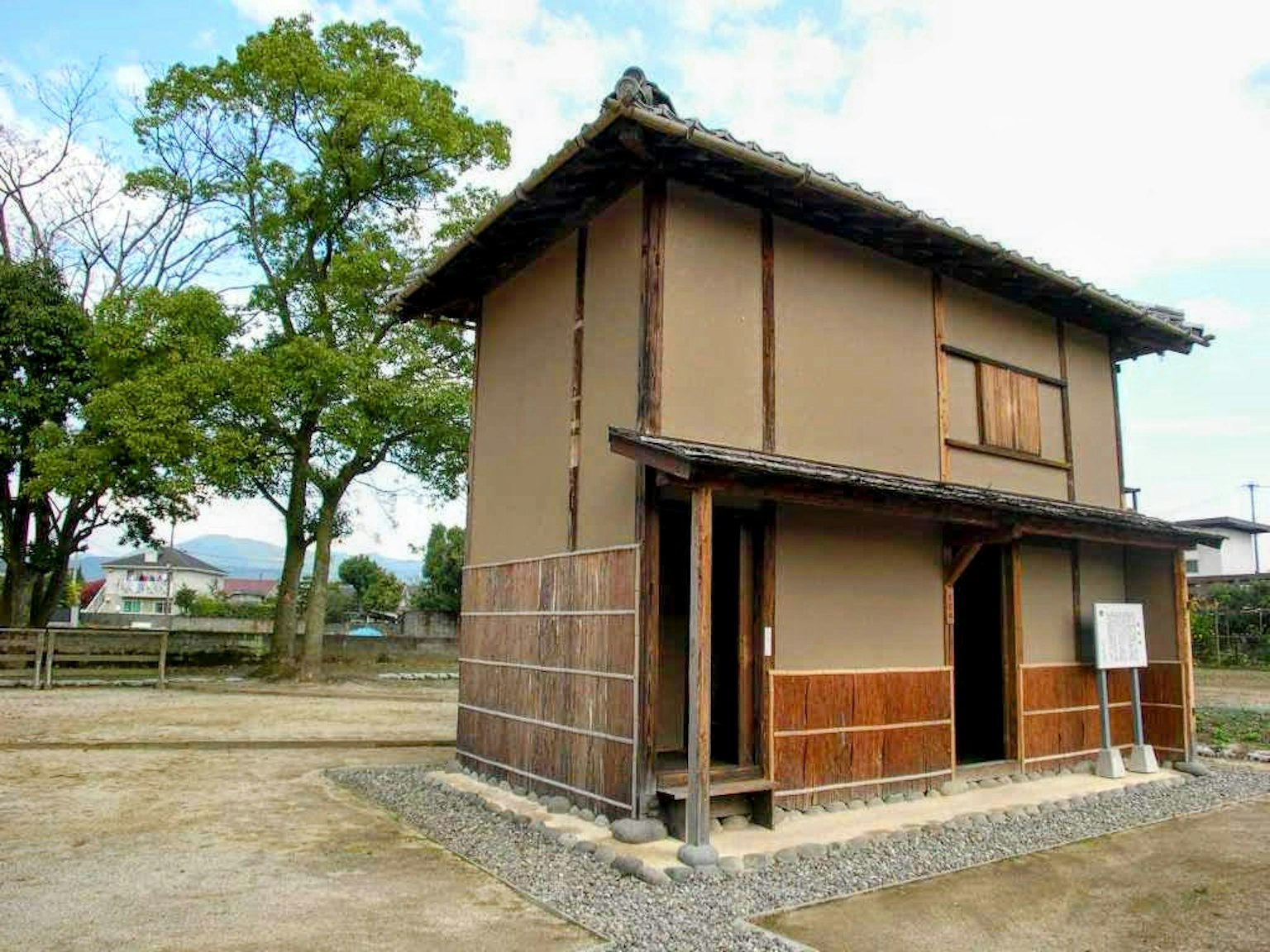 Exterior de una casa japonesa tradicional con vegetación exuberante de fondo