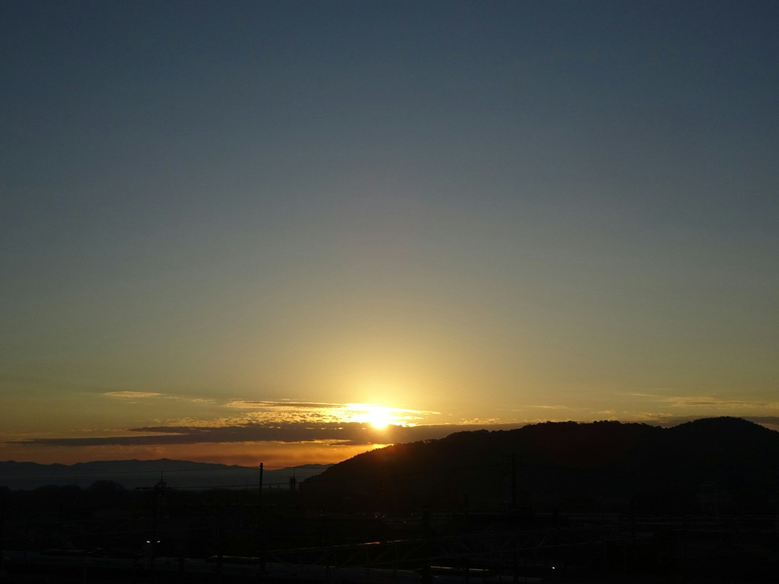 Beautiful sunset landscape with sun setting over hills