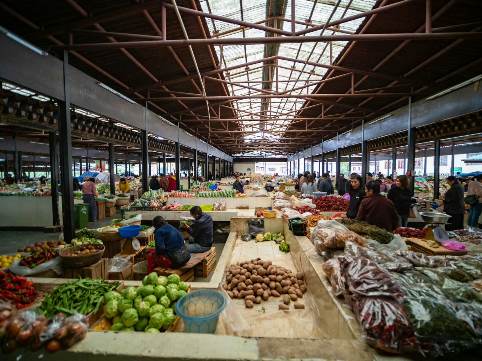 Vista interna di un mercato pieno di frutta e verdura colorata