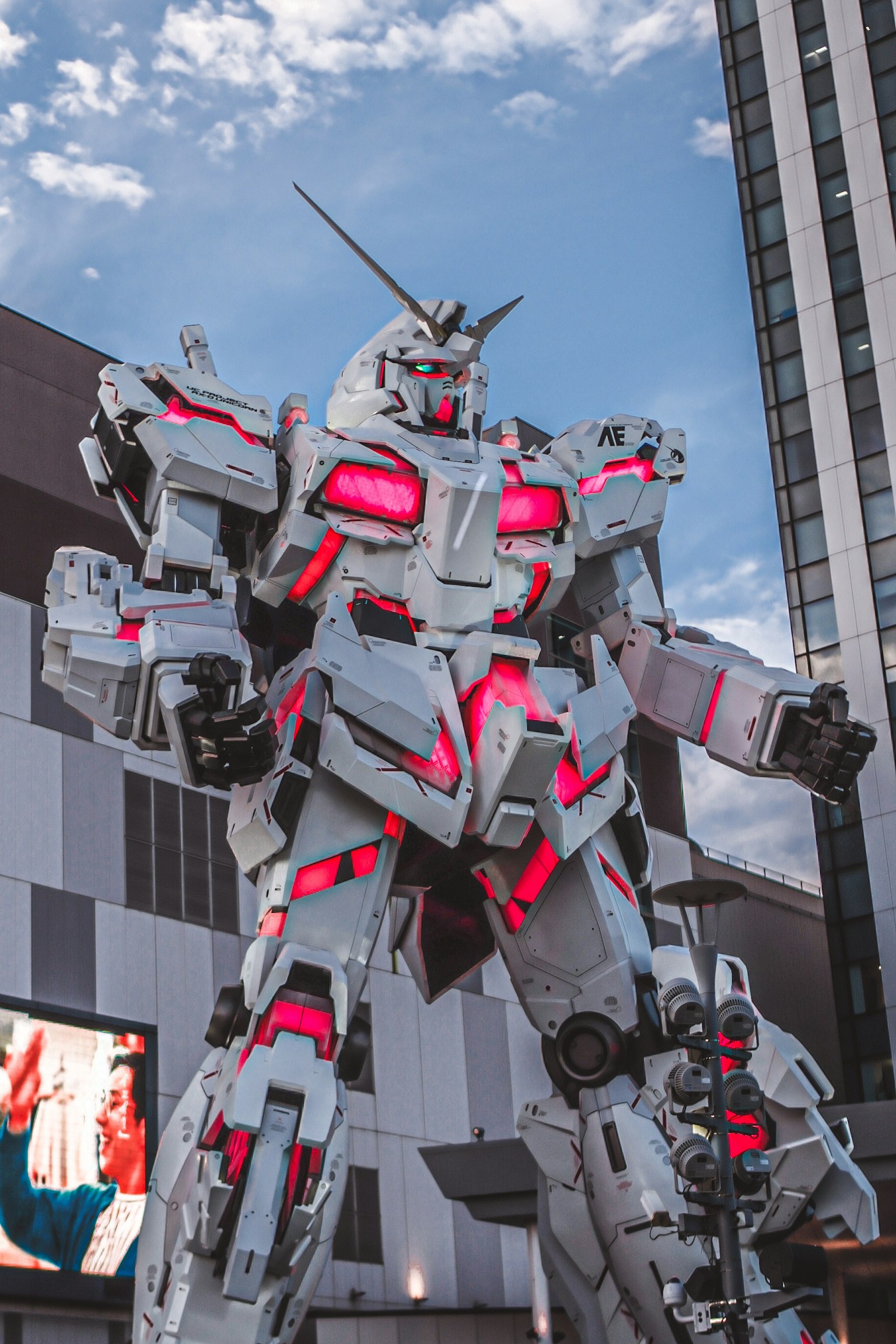 Una statua gigante di robot Gundam si erge in un contesto urbano