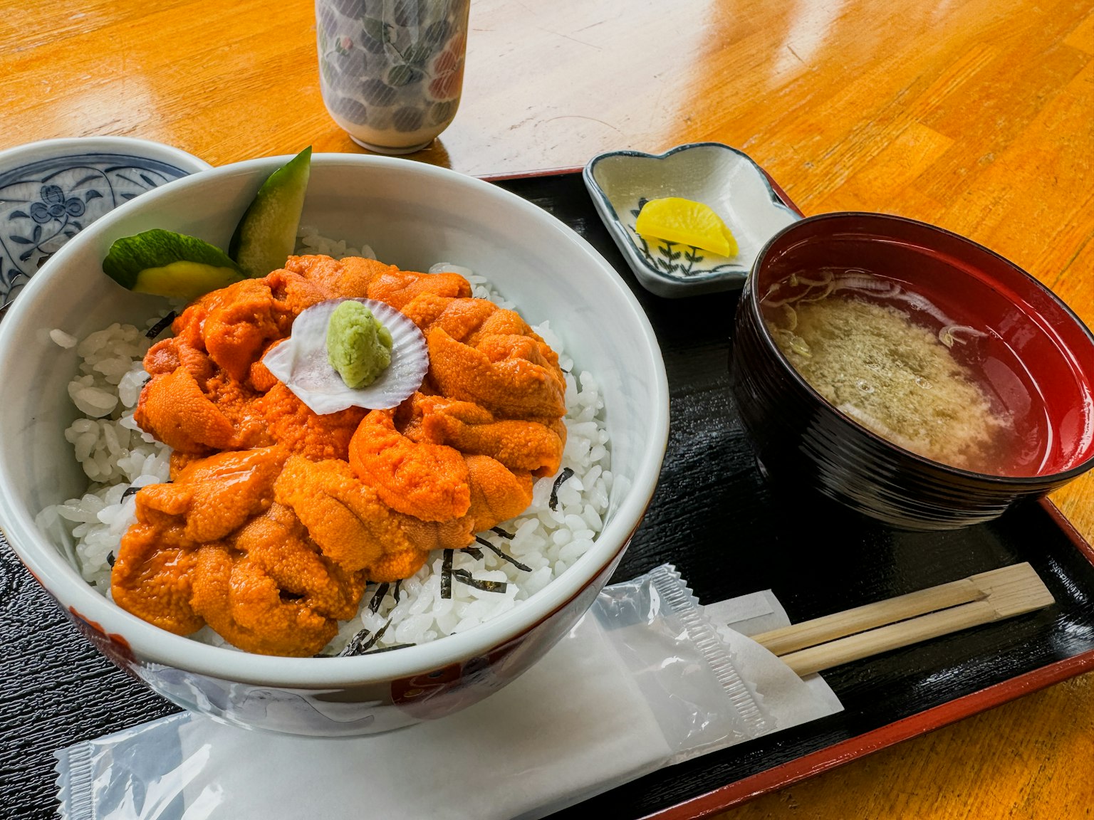 Eine köstliche Schüssel Seeigel auf weißem Reis mit Wasabi garniert