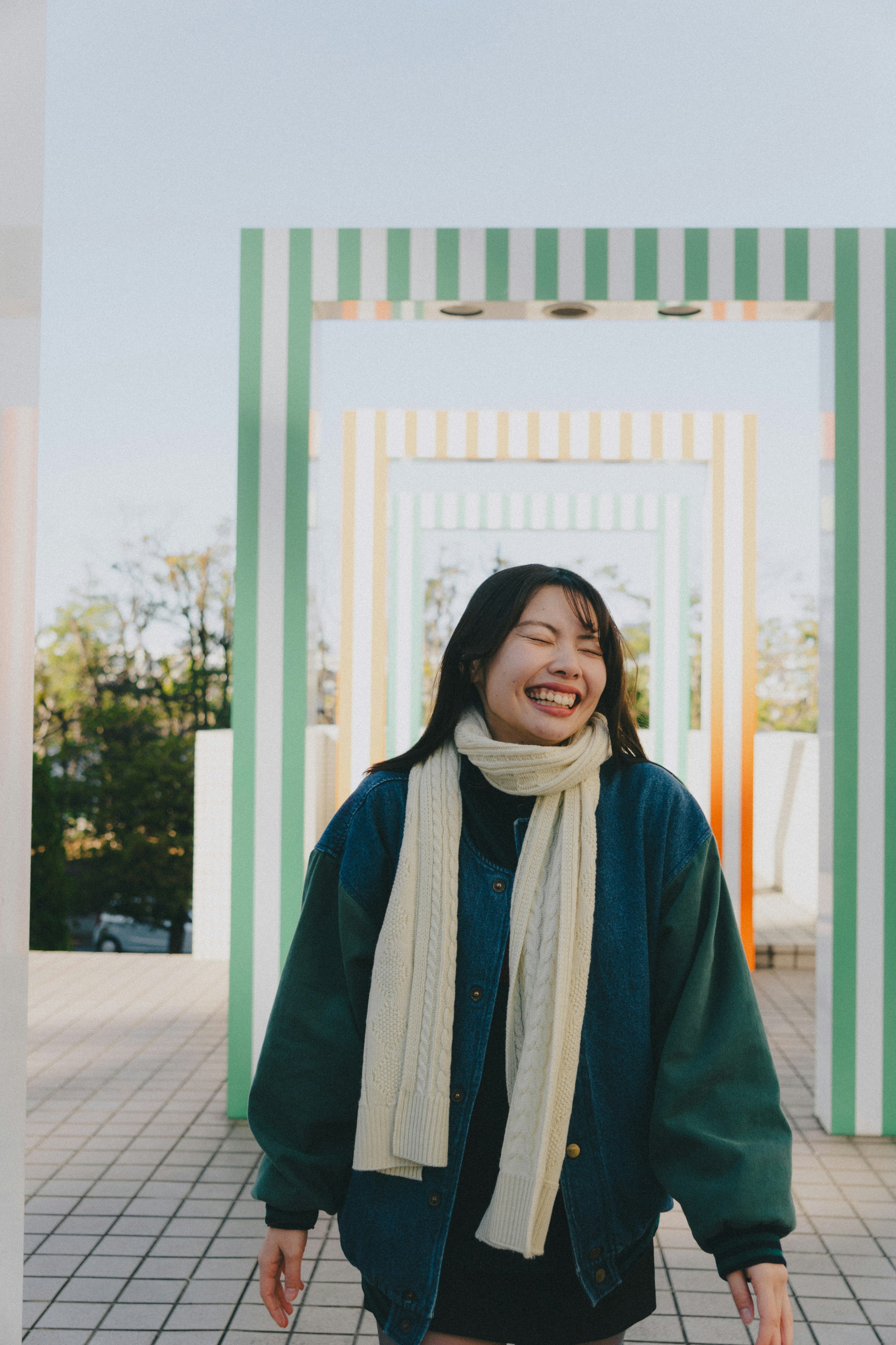 Femme souriante devant une arche vert et blanc