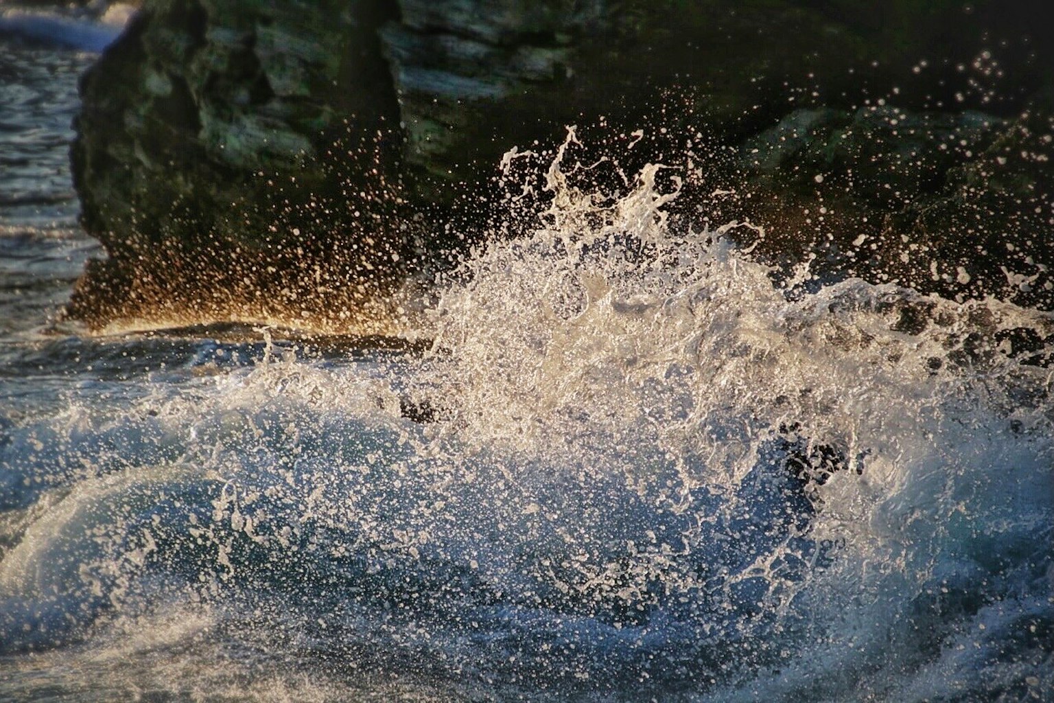 Ozeanwellen, die gegen Felsen schlagen und Wasserspritzer erzeugen