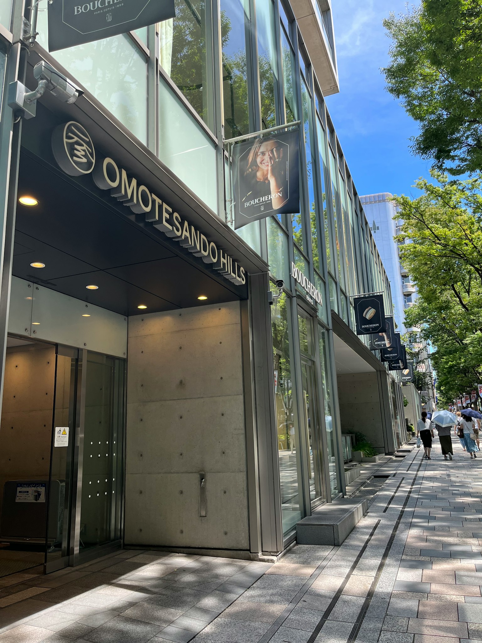 Cửa vào tòa nhà Omotesando với kiến trúc hiện đại và cảnh đường đi bộ