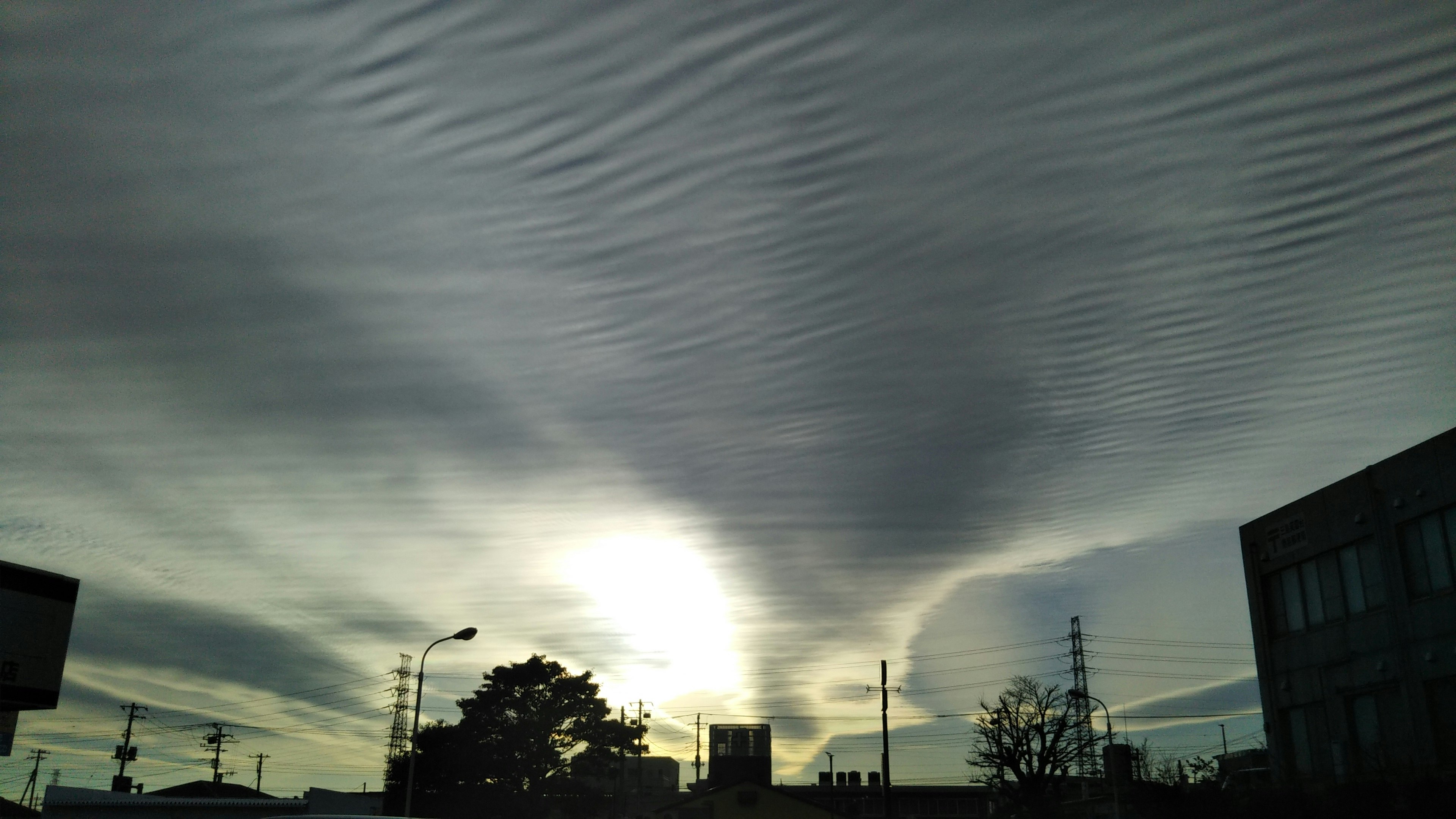 夕暮れの空に広がる雲と街並みのシルエット