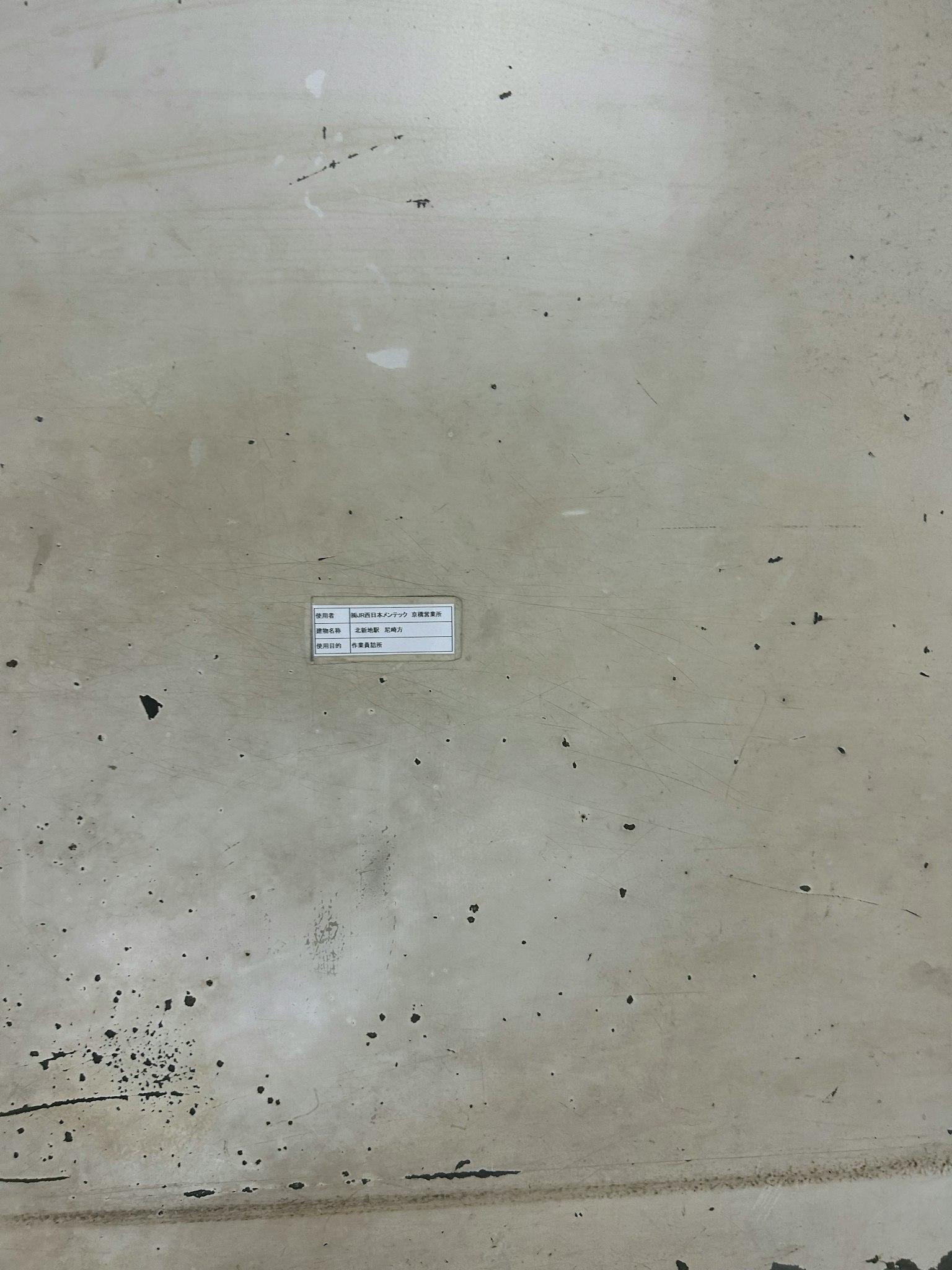 Etikett auf einem Betonboden mit sichtbaren Flecken
