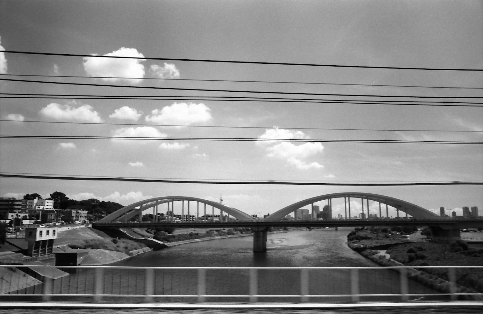 Paesaggio in bianco e nero con un ponte curvo su un fiume