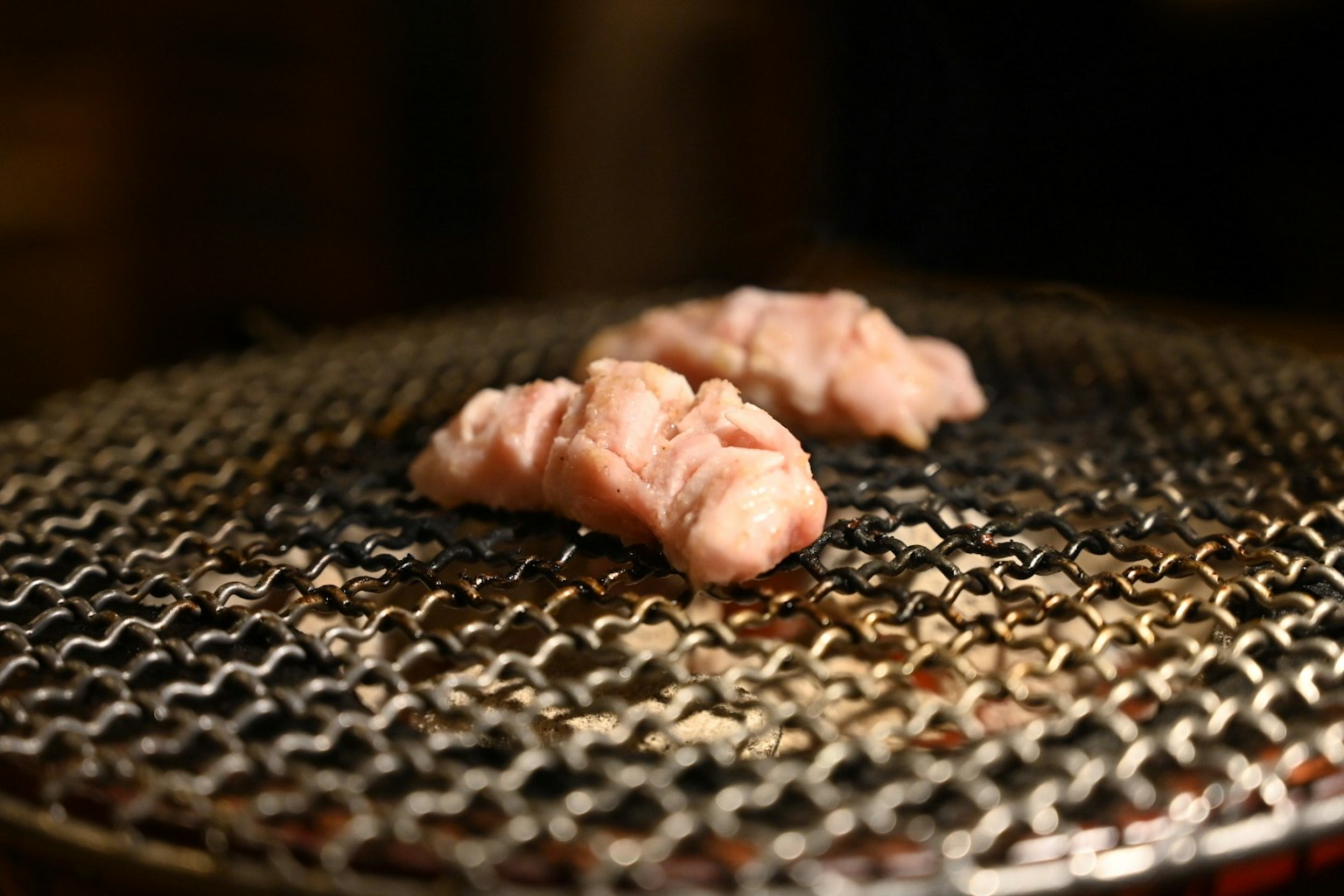 Potongan daging sedang dipanggang di atas jaring kawat
