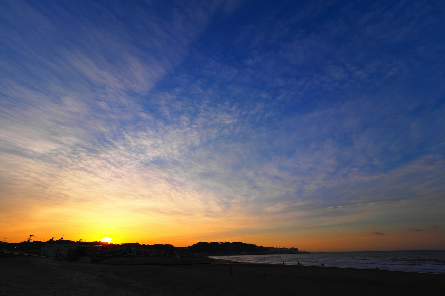 Hermosa escena de playa al atardecer con cielo azul y sol anaranjado