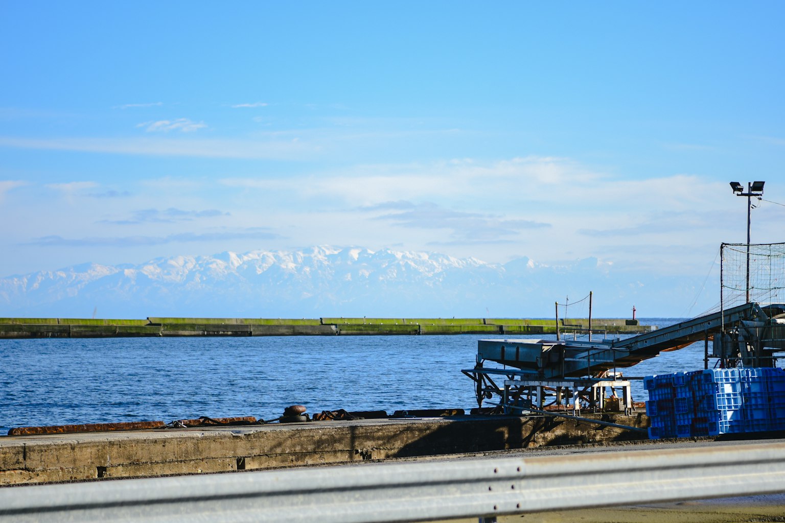 Une vue pittoresque d'un port avec des montagnes enneigées en arrière-plan sous un ciel bleu