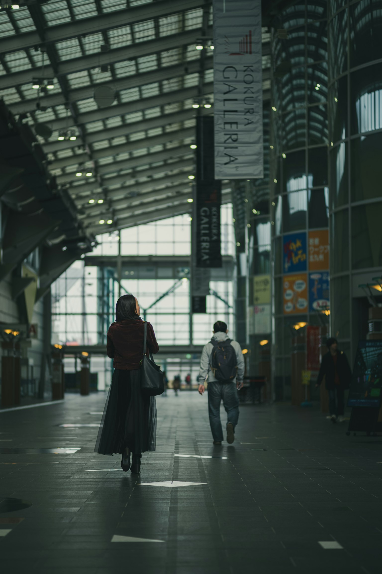 สองคนที่เดินอยู่ในสถานีรถไฟทันสมัย