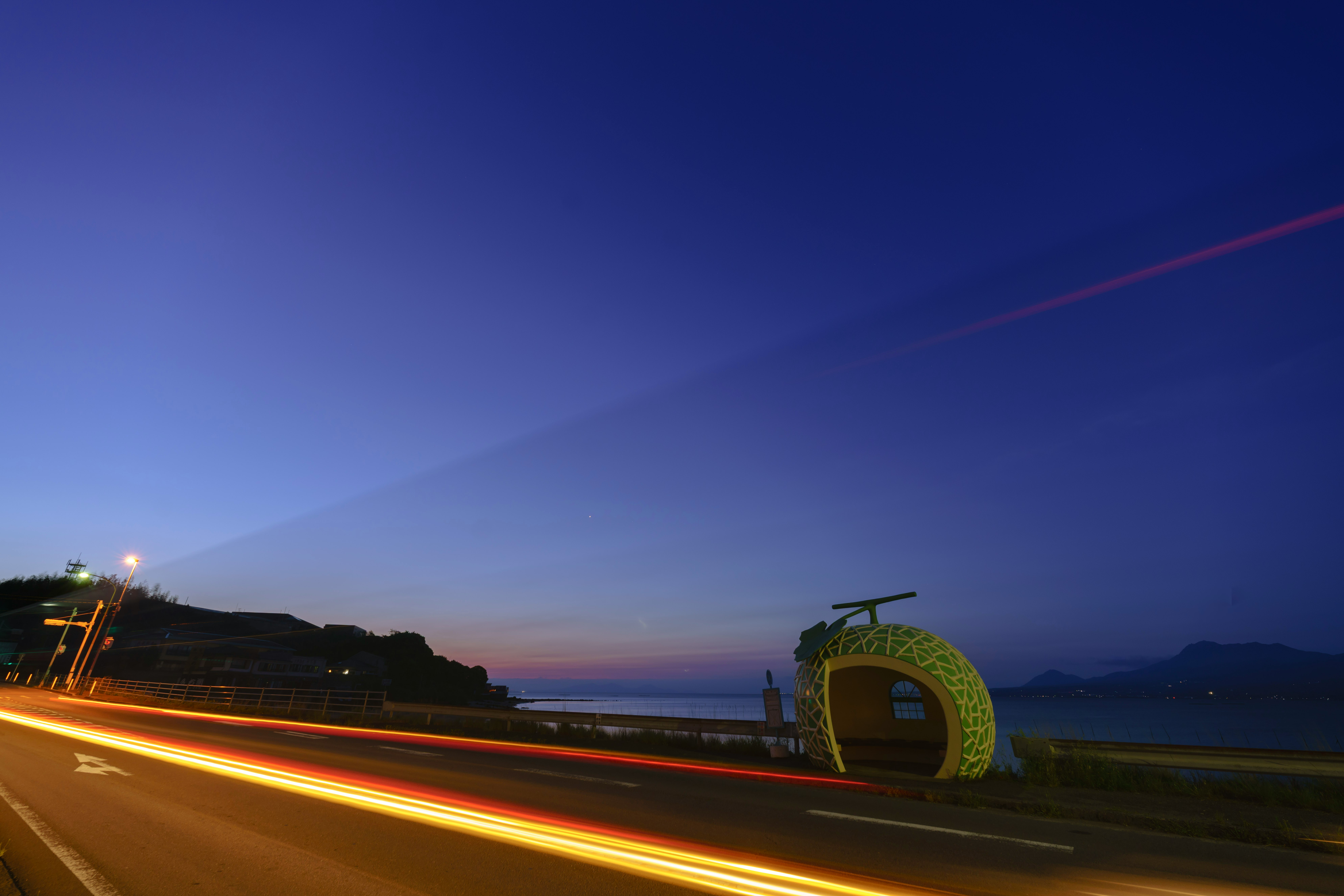 海邊水果公車站旁的夜間道路景