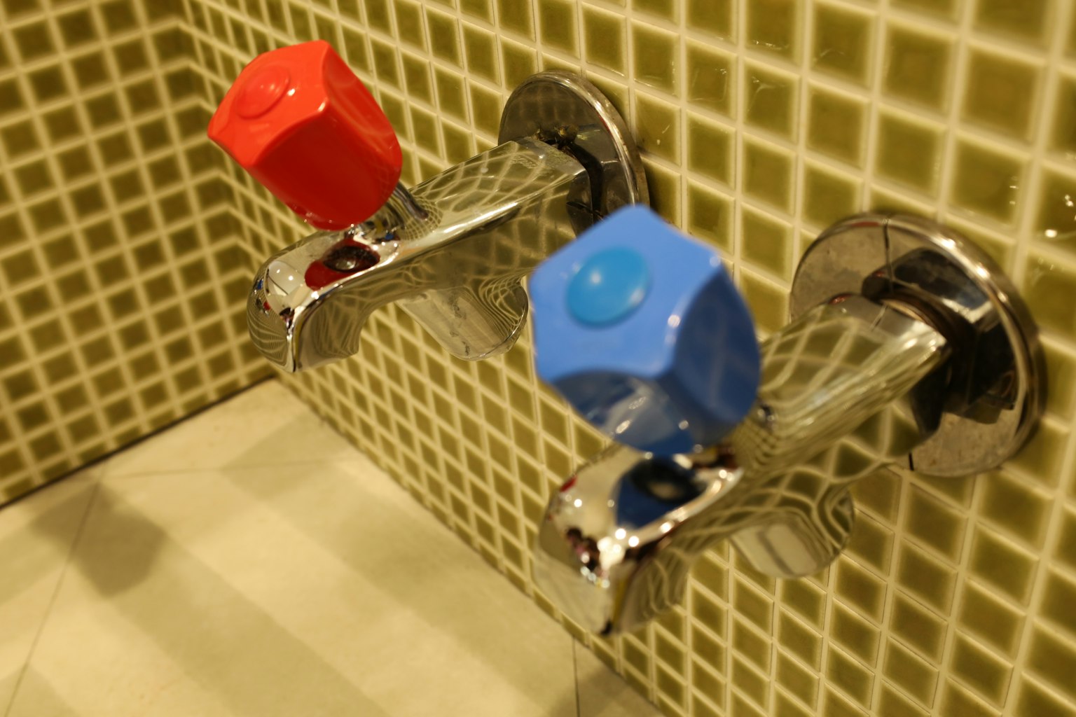 Nahaufnahme von Wasserhähnen mit roten und blauen Griffen