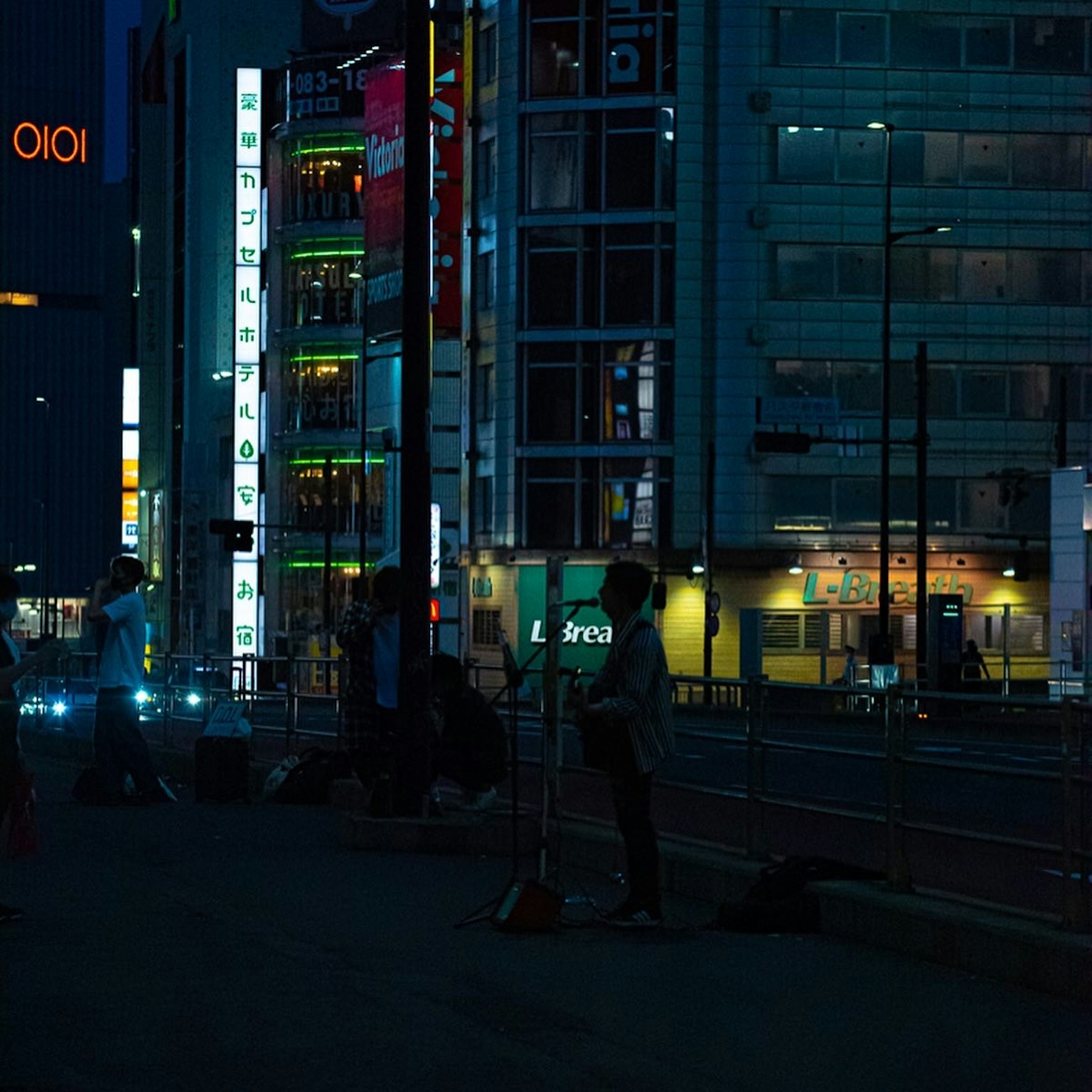 夜晚城市景观，有人和明亮的招牌