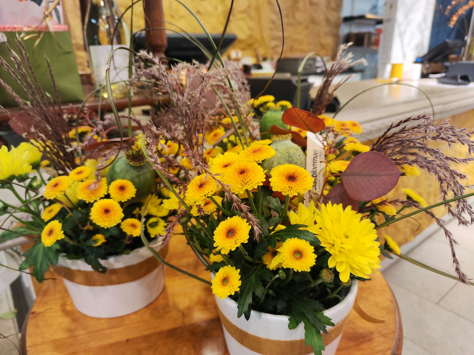 Arrangement floral avec des fleurs jaunes vives et des feuilles vertes dans des pots décoratifs