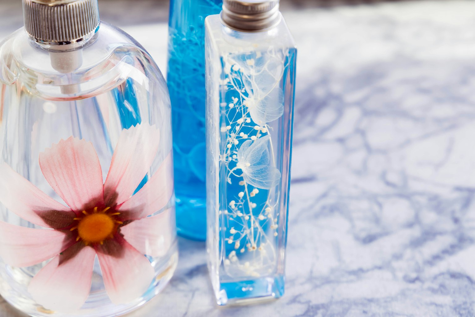 Chai trong suốt có hoa và chất lỏng màu xanh