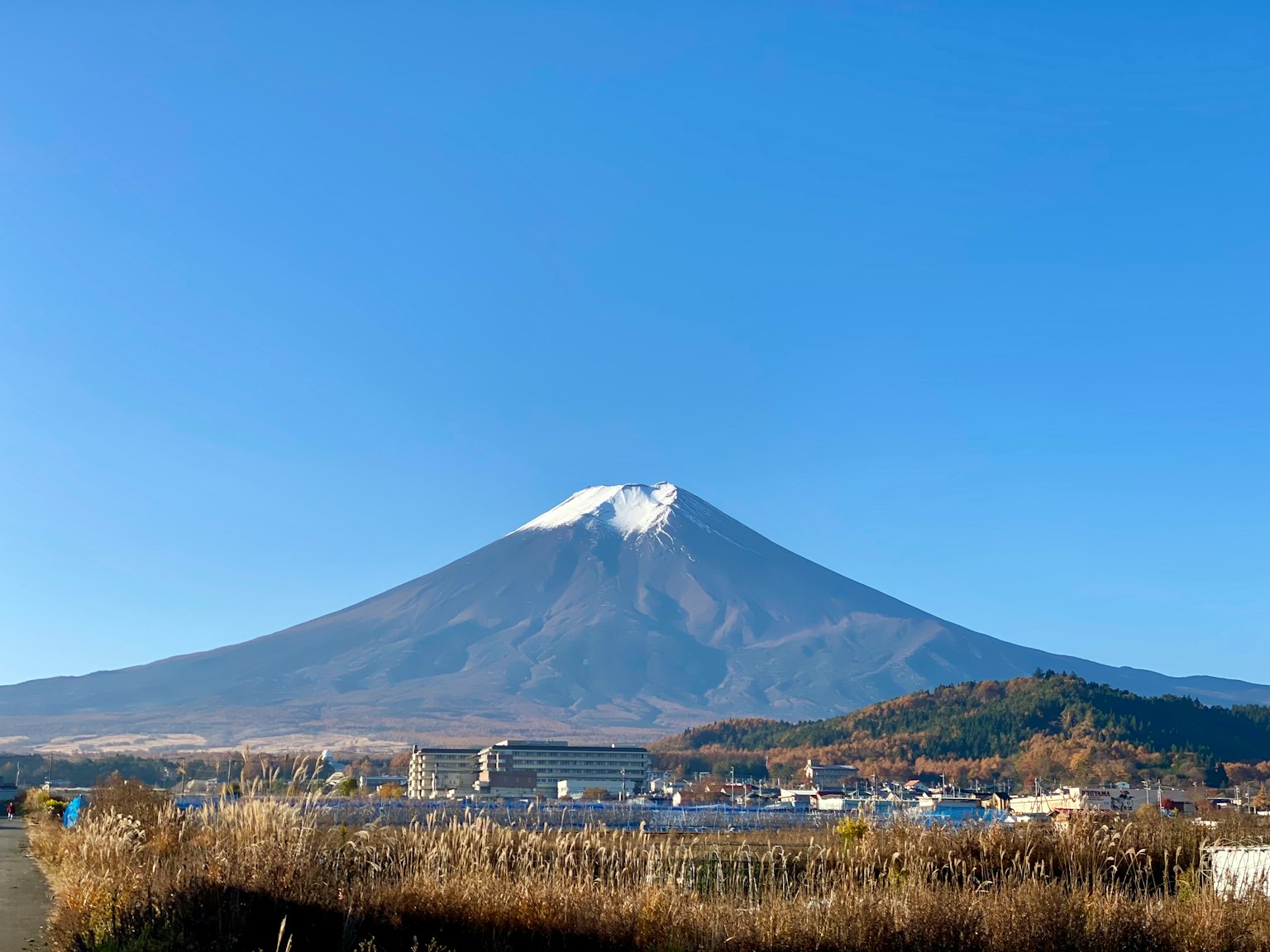 富士山在晴朗的藍天下的美麗景色，雪頂和附近的城鎮