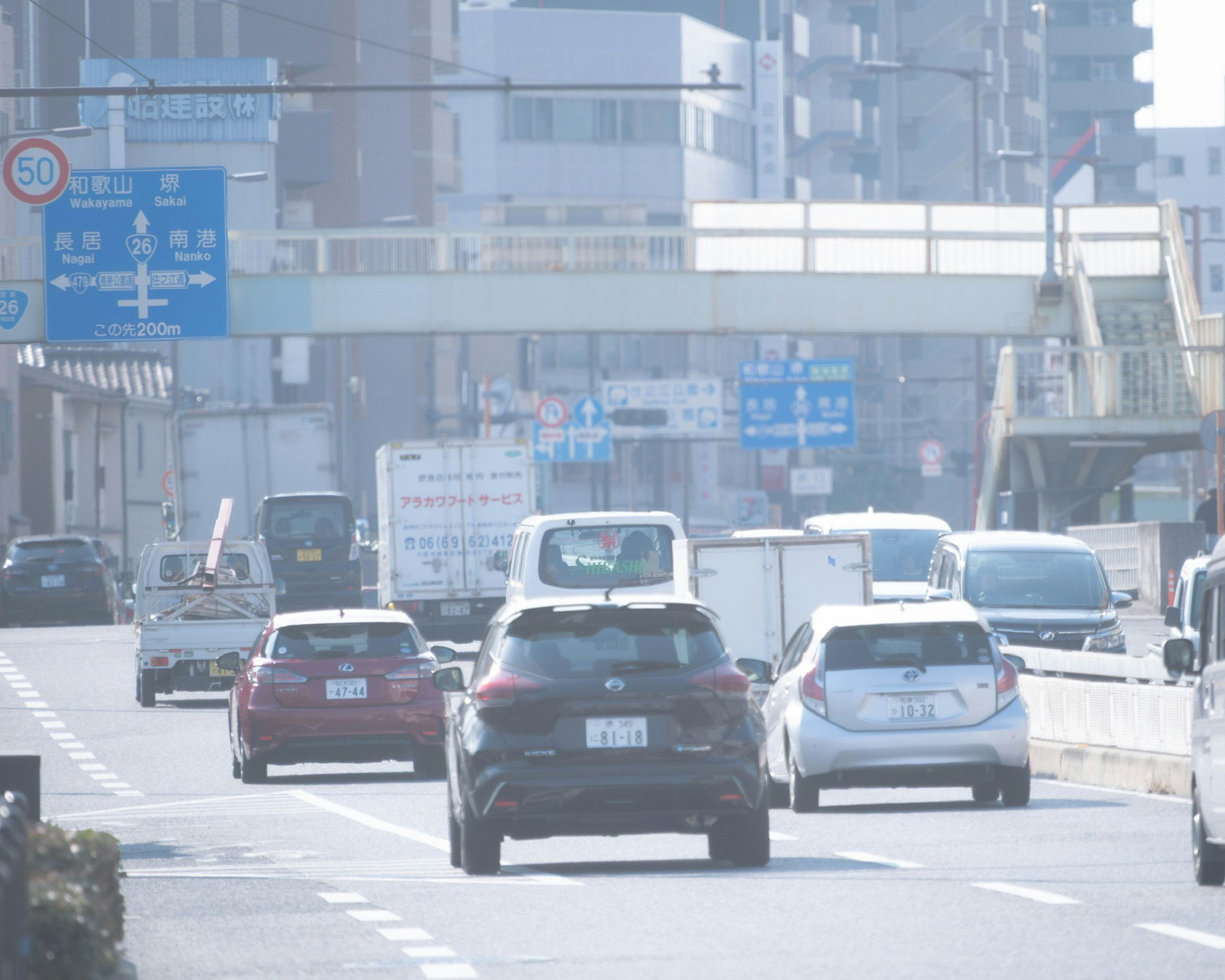 都市の道路を走る車両と交通標識