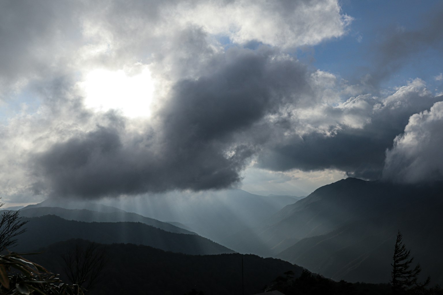 Paesaggio di montagne coperte di nuvole con la luce del sole che filtra
