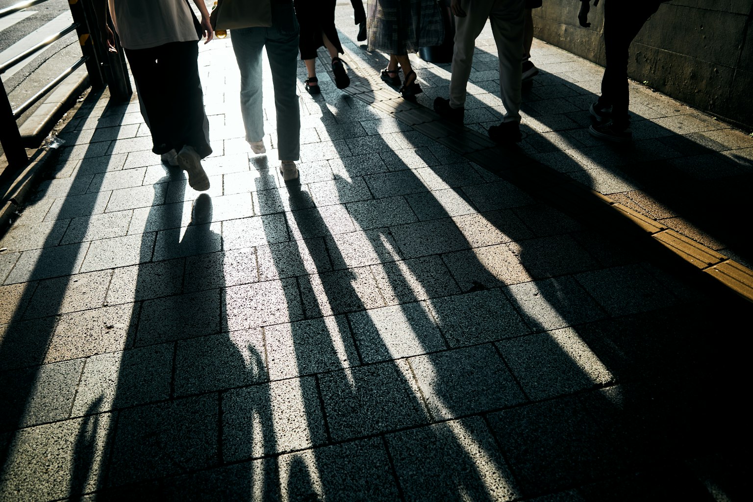 Una vista de peatones proyectando largas sombras en una acera