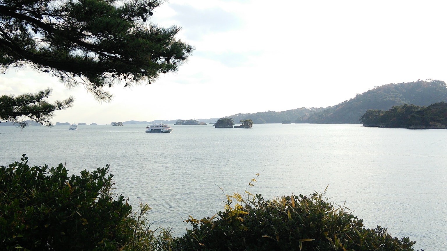 Vista panoramica del mare calmo con isole lontane e vegetazione