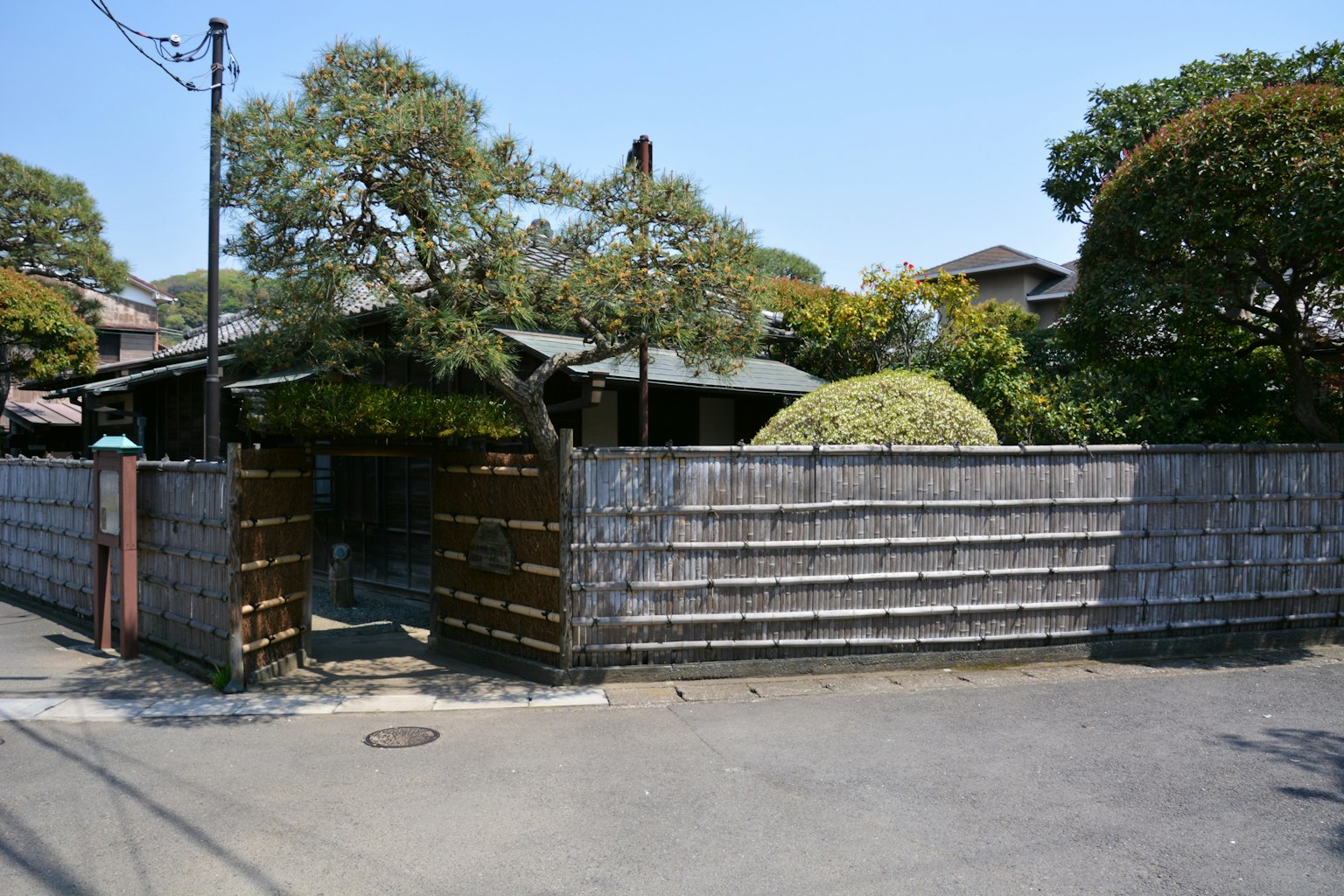 Traditionelles japanisches Haus mit Bambuszaun und üppigem Garten