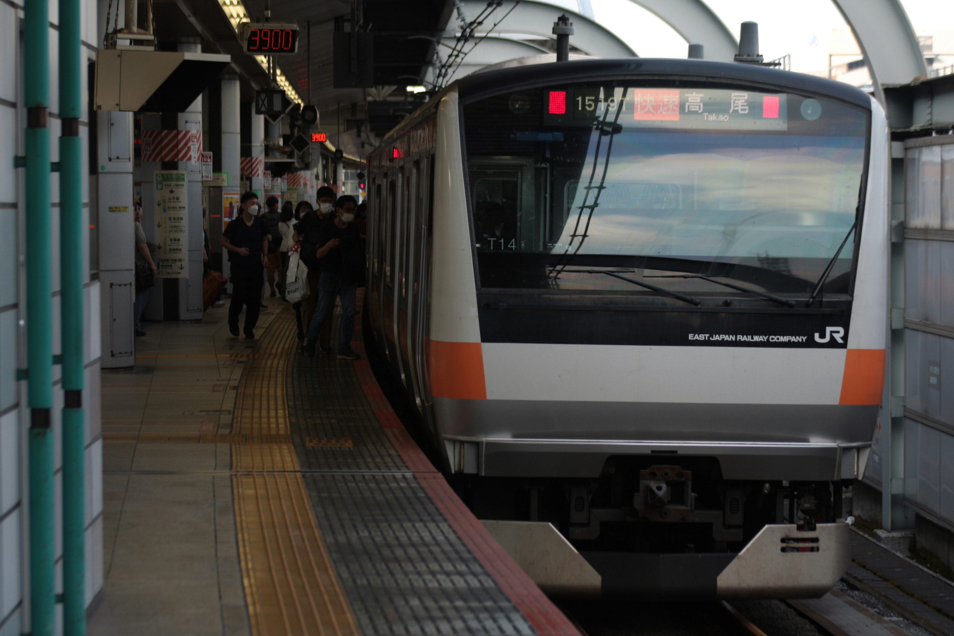 JR特快列車停靠在月台，乘客在旁