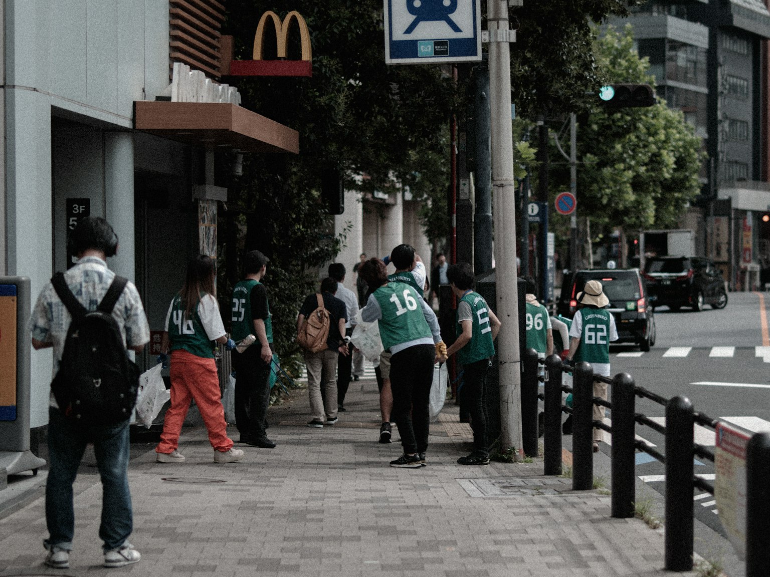 Persone in fila davanti a McDonald's con staff in uniformi verdi