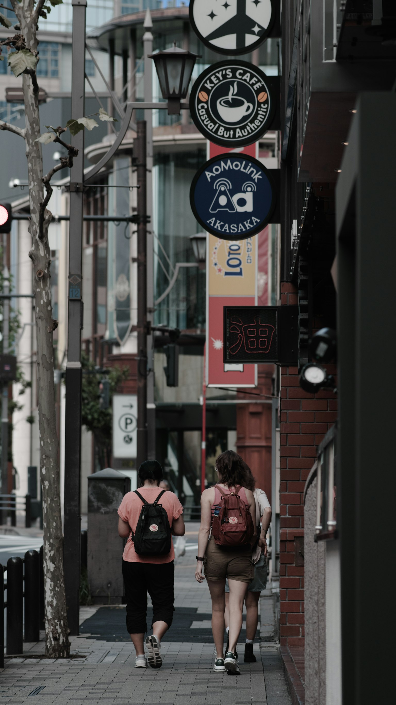 兩名女性在街上行走，背景可見商店招牌