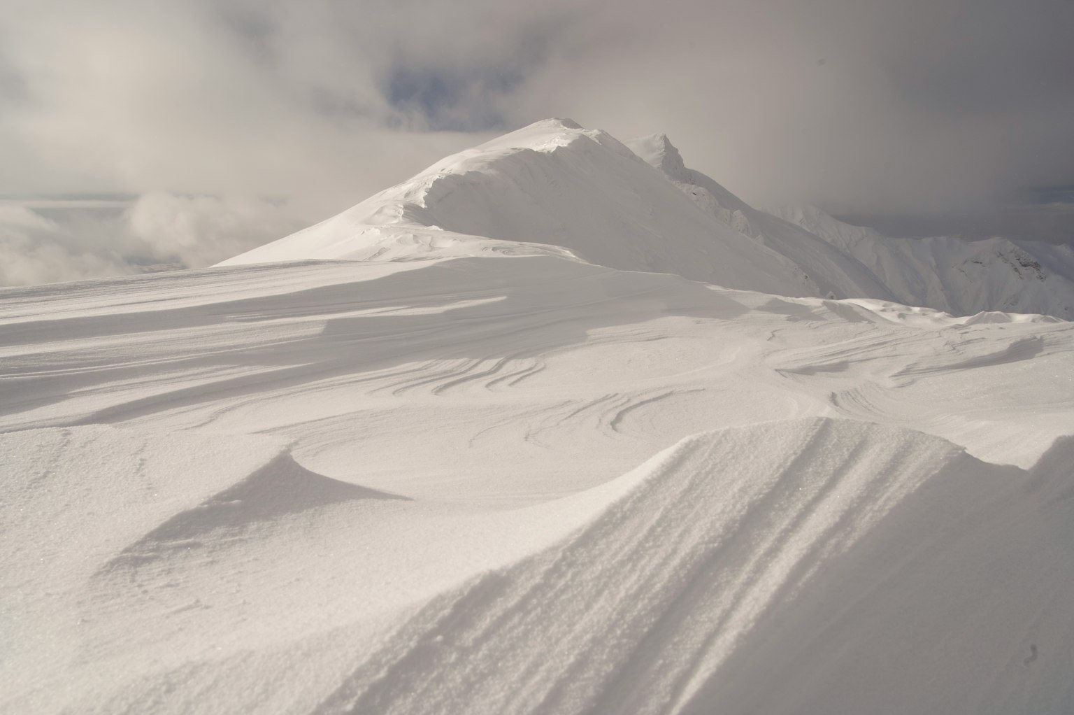 Snow-covered mountain landscape with soft curves and undulations
