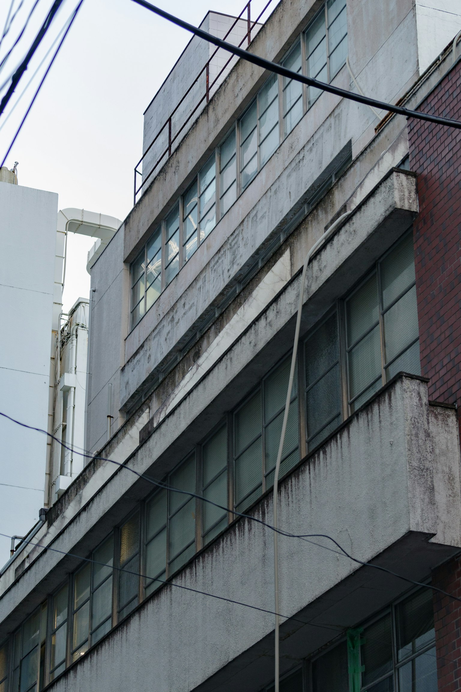 Esterno di un vecchio edificio con grandi finestre e facciata logora
