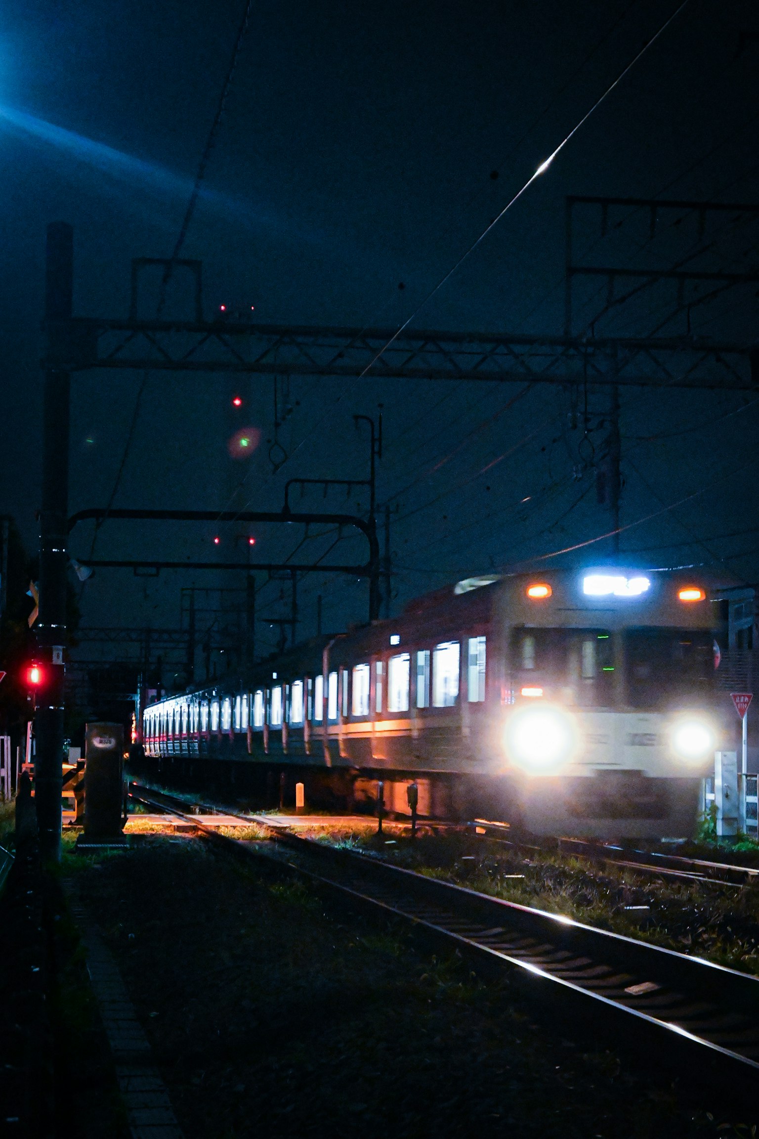 Tren en movimiento por la noche con luces de señal iluminadas