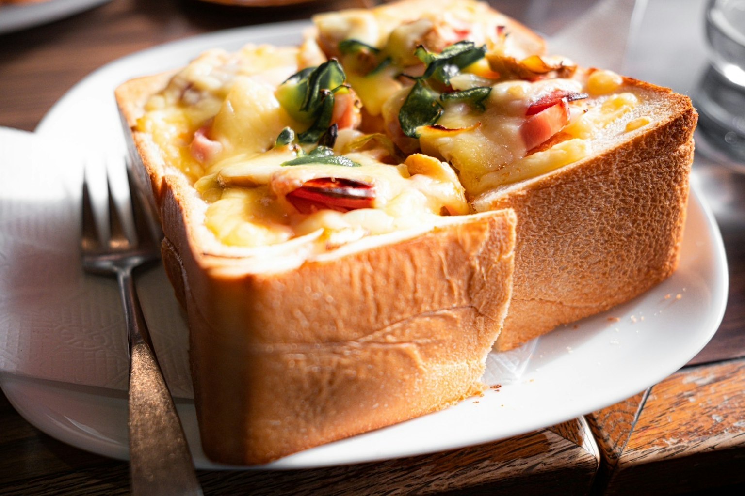 Pan tostado cubierto con queso y verduras
