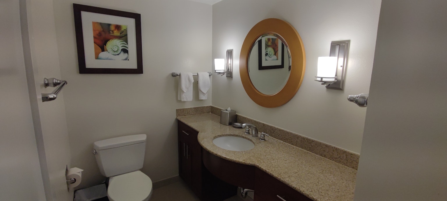 Bagno luminoso con specchio rotondo asciugamani e arte murale