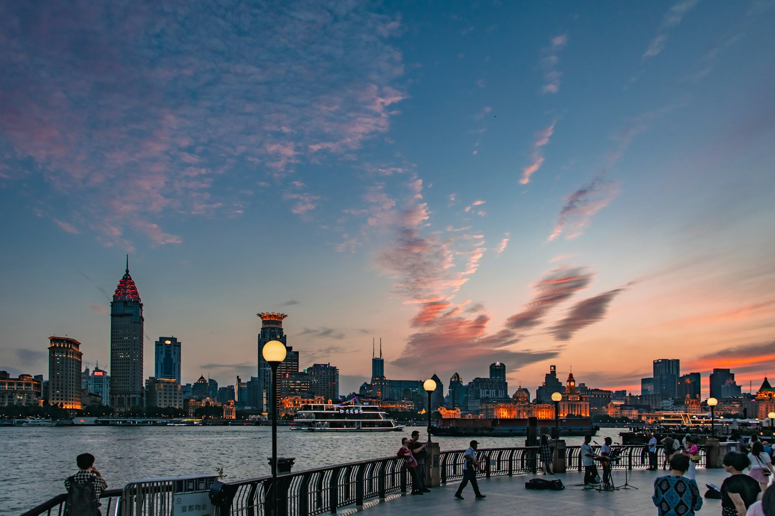Skyline di Shanghai al tramonto con persone sul lungomare