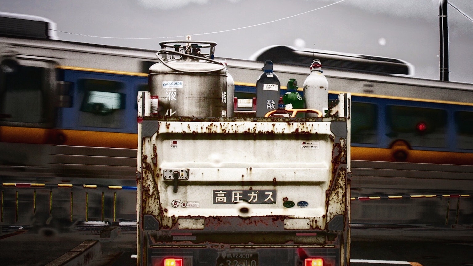 Lavoratori su un camion sporco con un treno di passaggio sullo sfondo