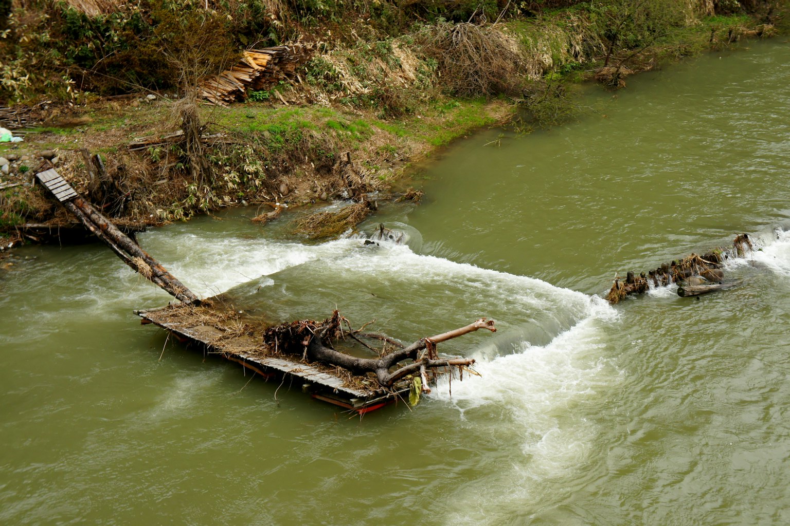 Restos de un barco de madera en agua corriente