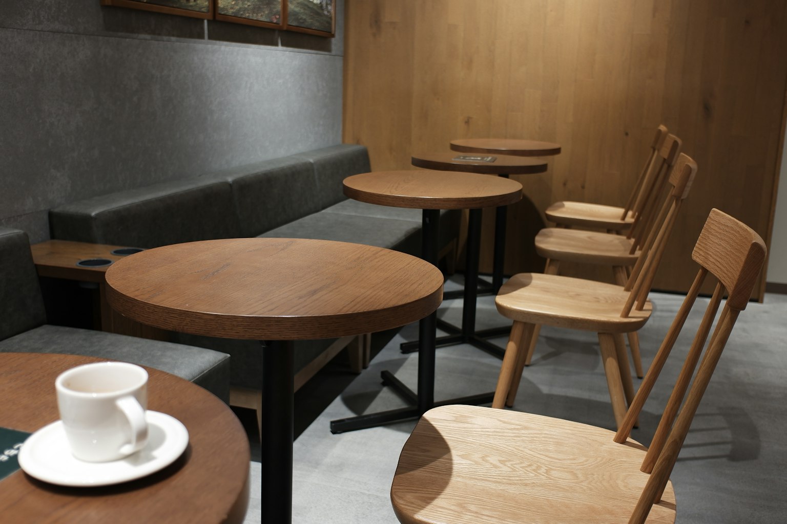 Interior de café simple con mesas y sillas de madera una taza de café sobre una mesa