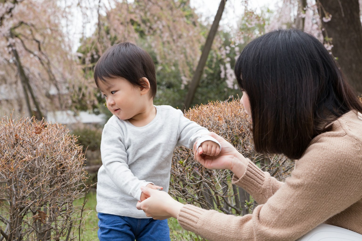 Un jeune garçon jouant avec sa mère dans un parc