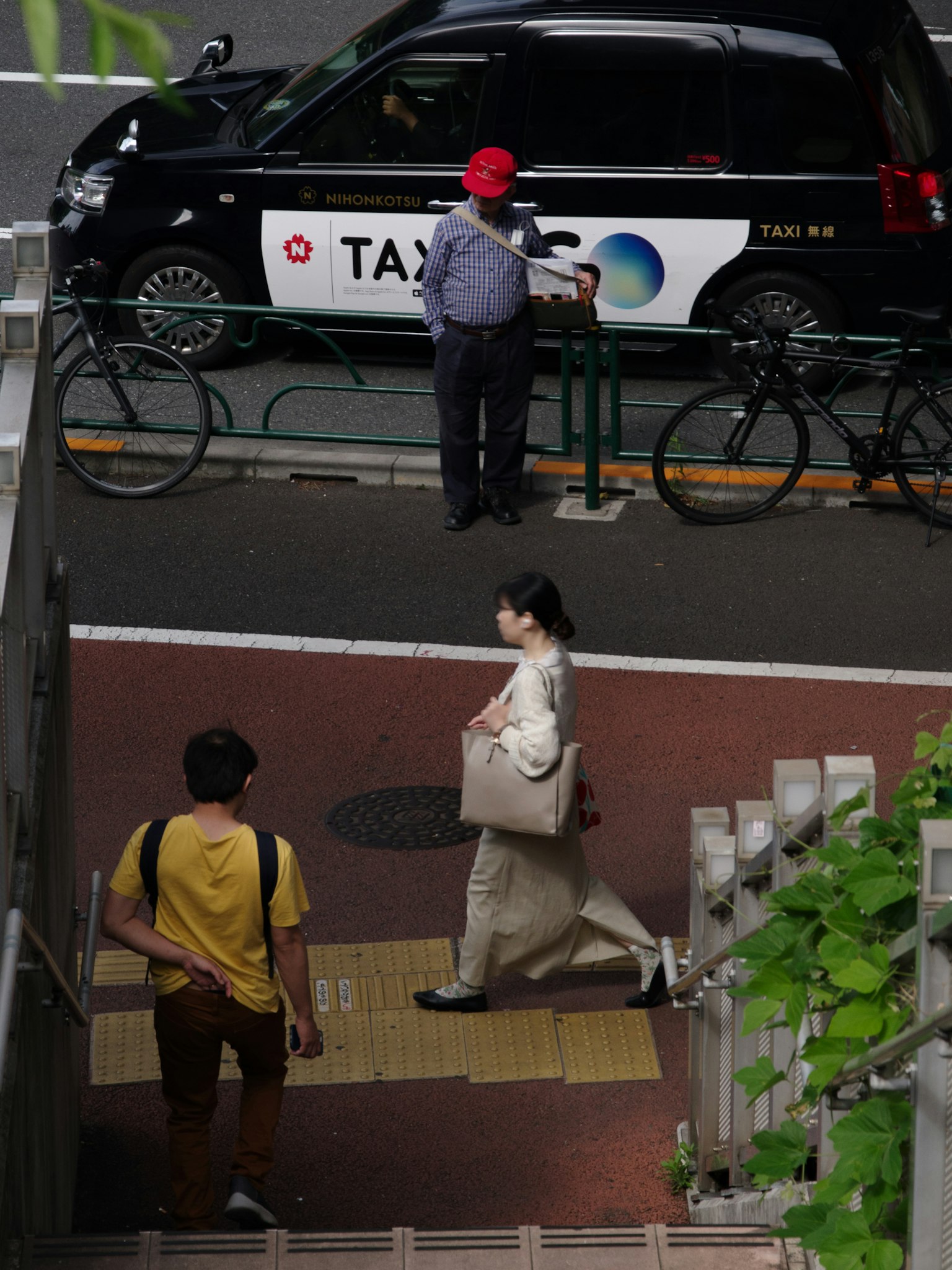 Một người phụ nữ đi bộ gần một chiếc taxi có xe đạp đậu gần đó
