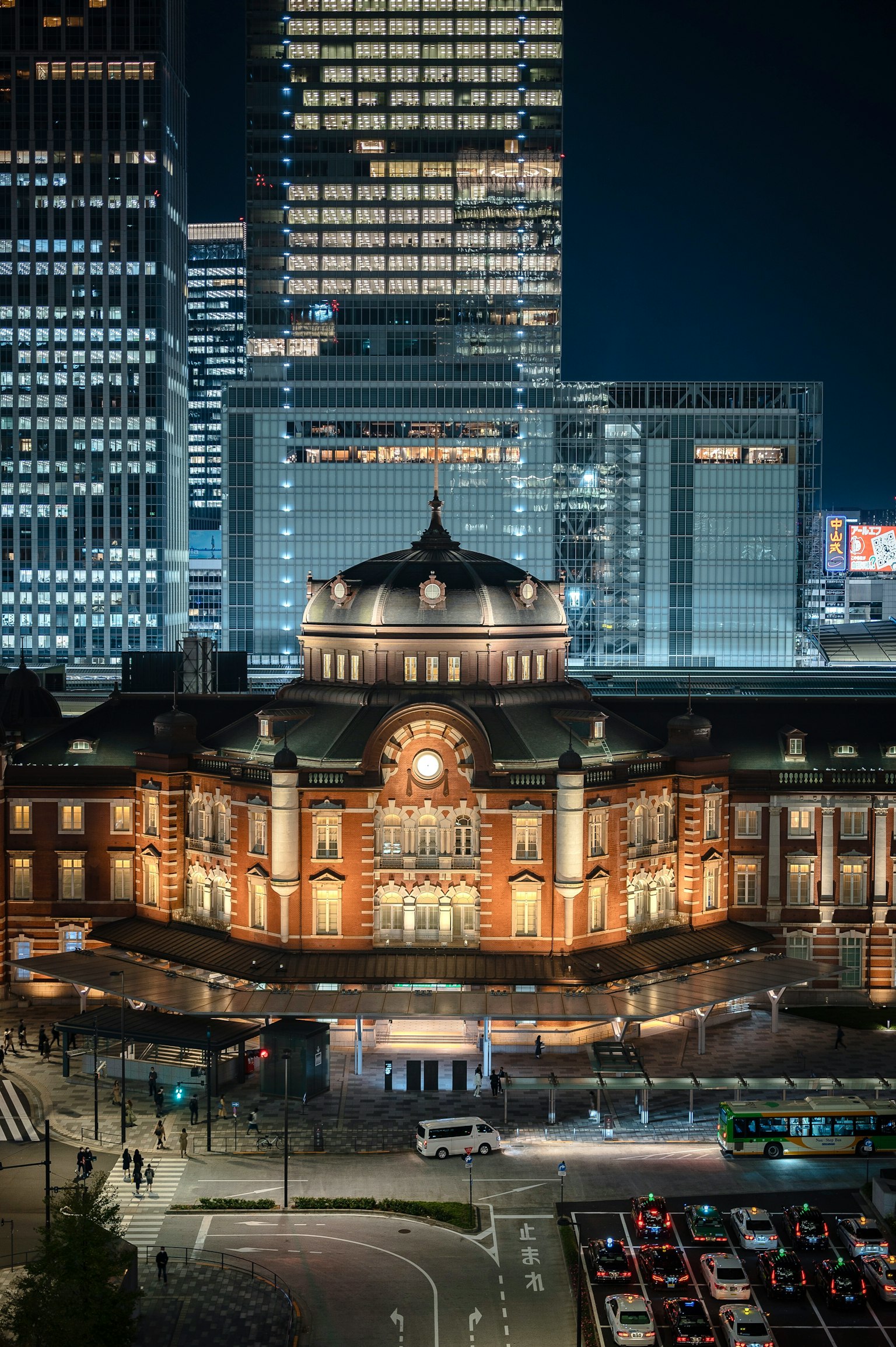 东京站的夜景与现代摩天大楼的背景