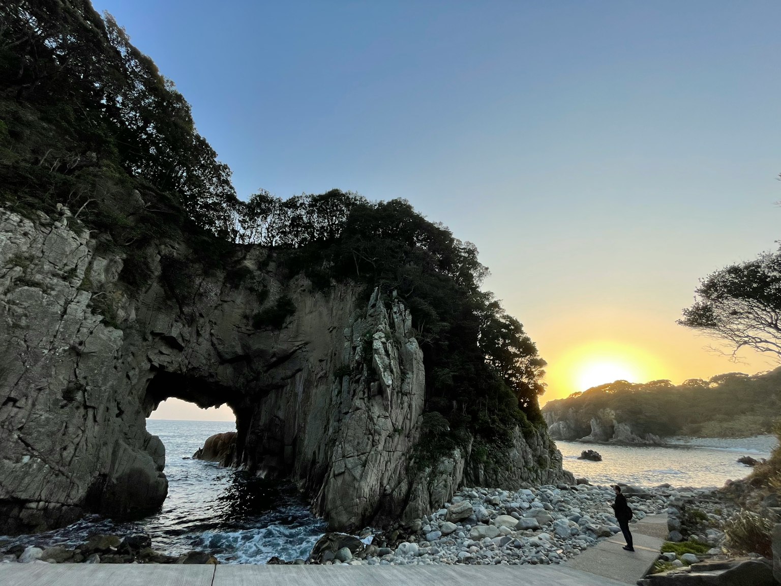 Cảnh bờ biển có vòm đá và hoàng hôn