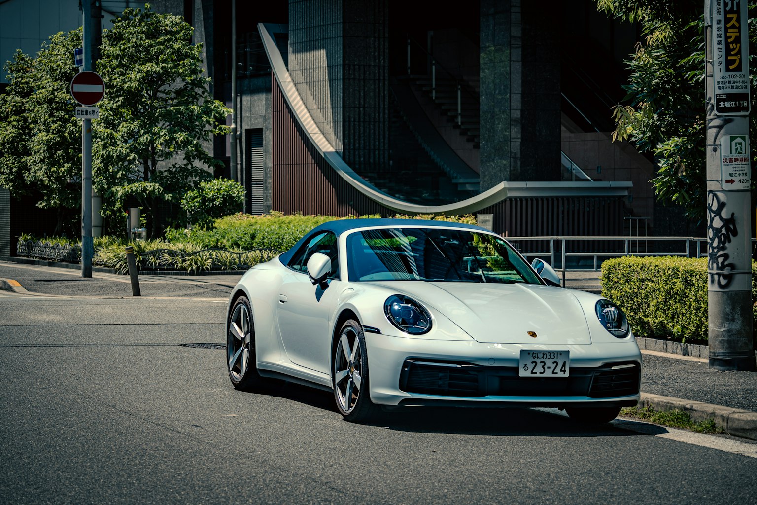 Porsche 911 putih melaju di jalan kota