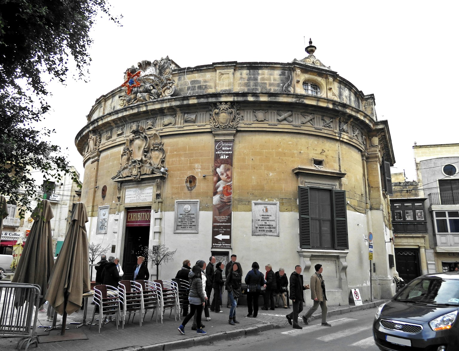 Edificio histórico de forma redonda con personas reunidas afuera
