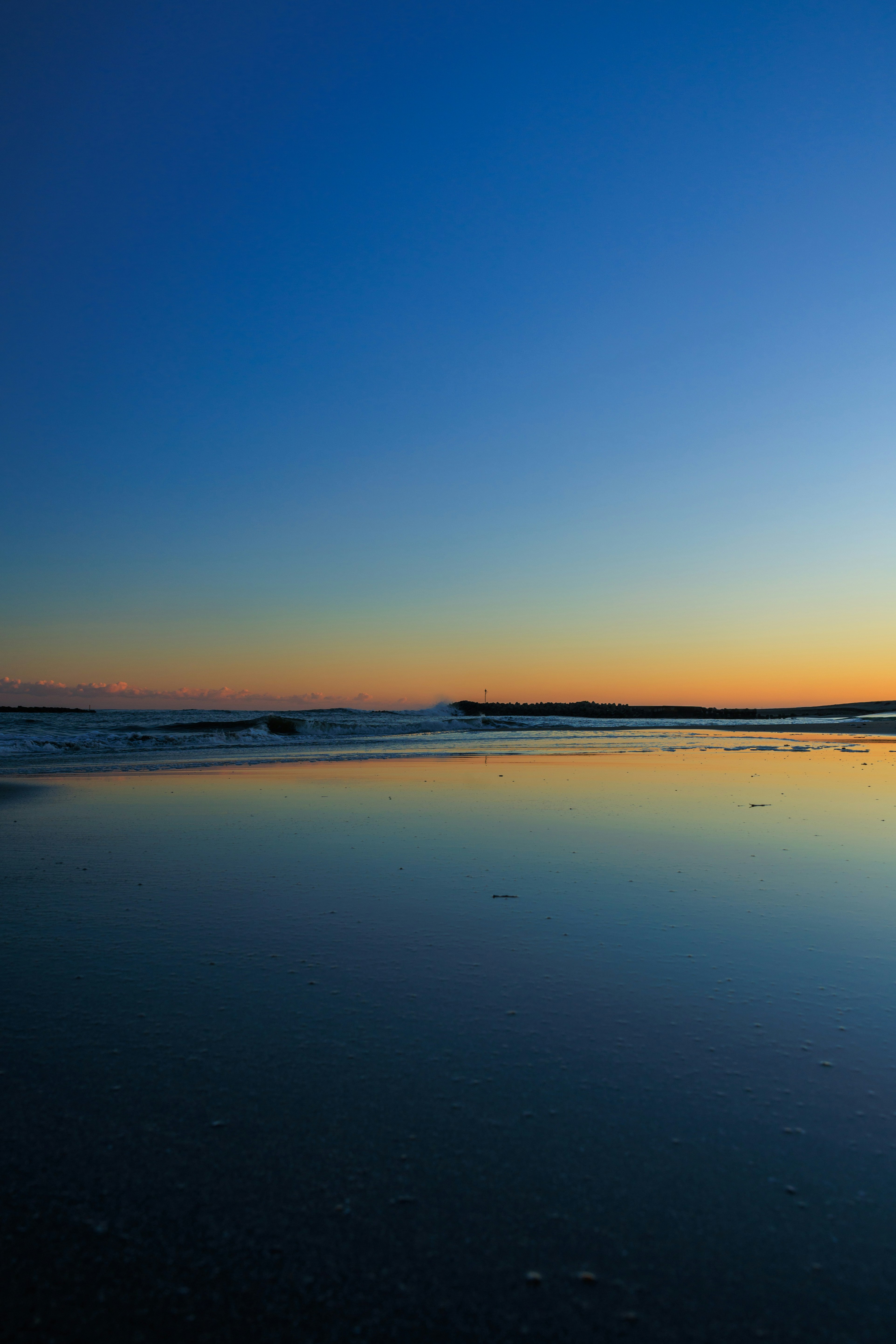 夕暮れの海辺に広がる静かな砂浜の風景