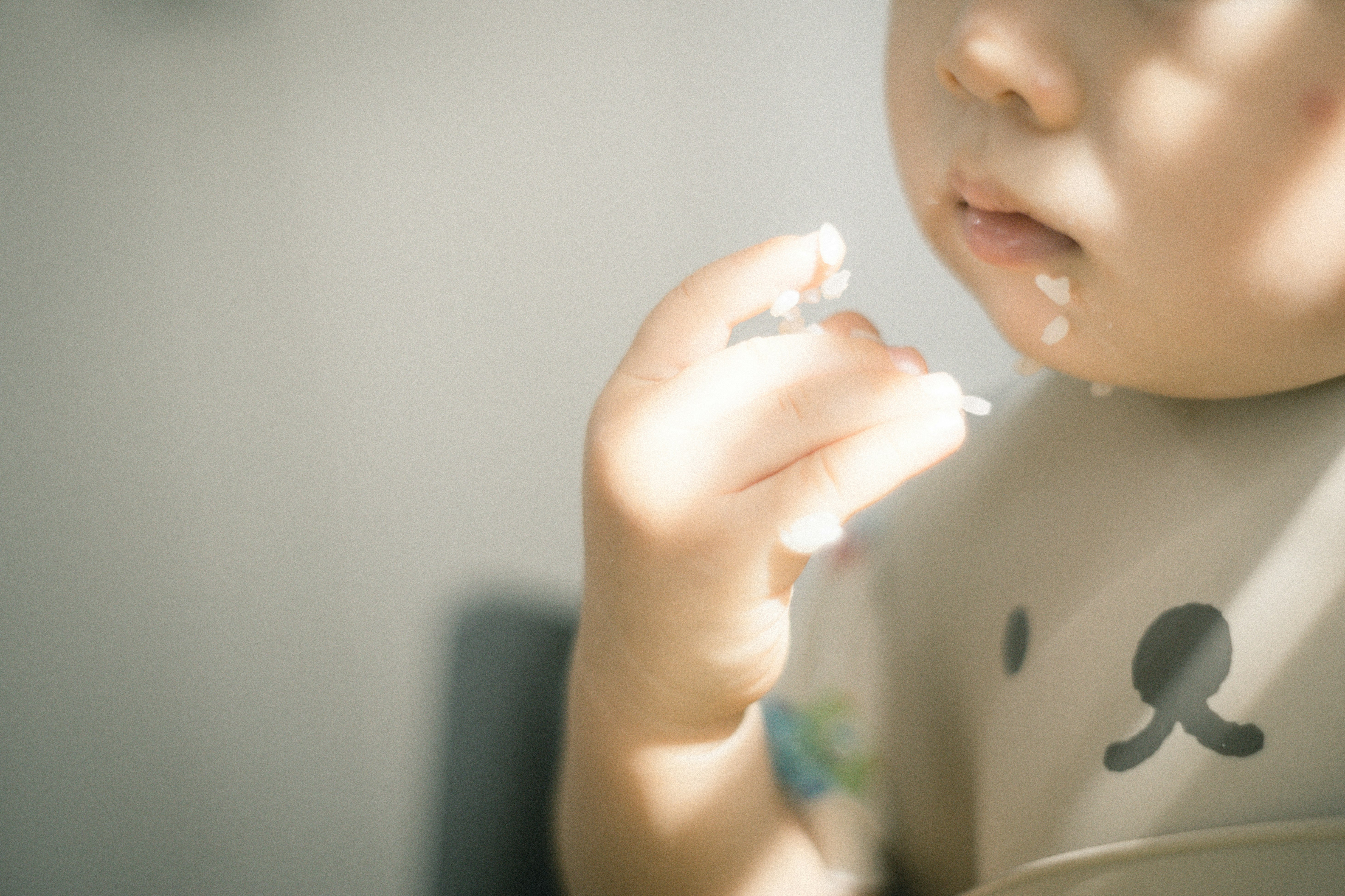 口元に食べ物のかけらが付いた子どもの食事シーン