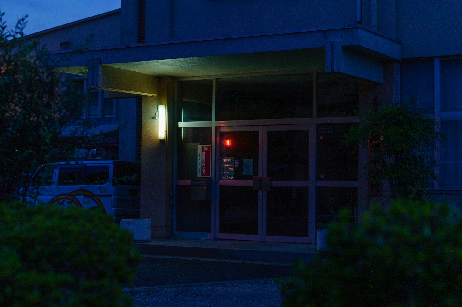 Entrada de un edificio con una luz roja brillando por la noche