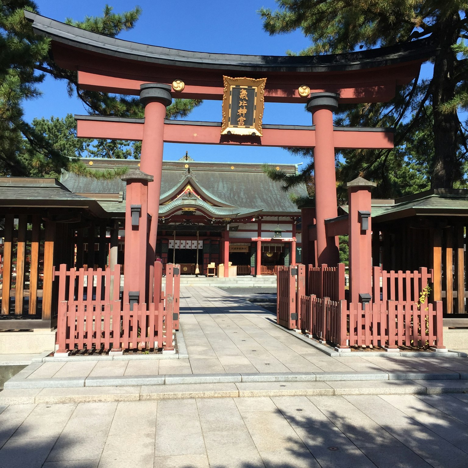 Beautiful shrine entrance with red torii gate under a clear blue sky