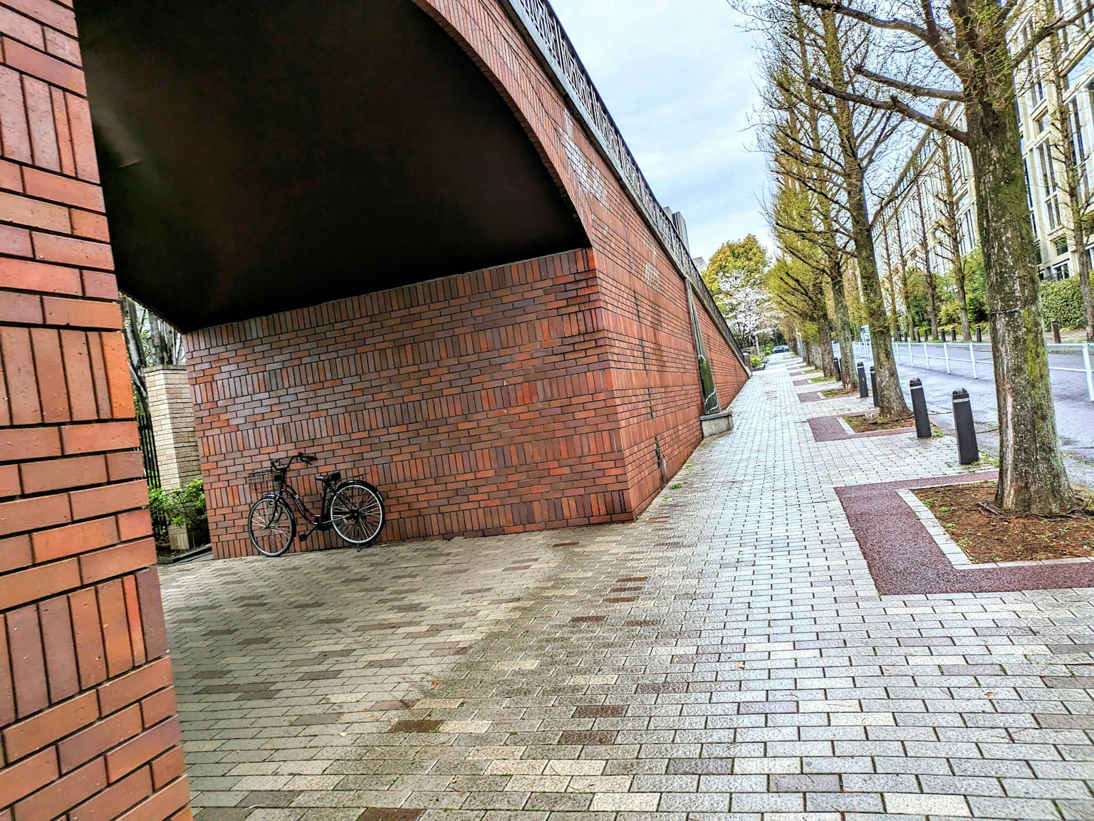 Blick auf einen Backbogen und einen gepflasterten Gehweg mit einem Fahrrad an der Wand gelehnt