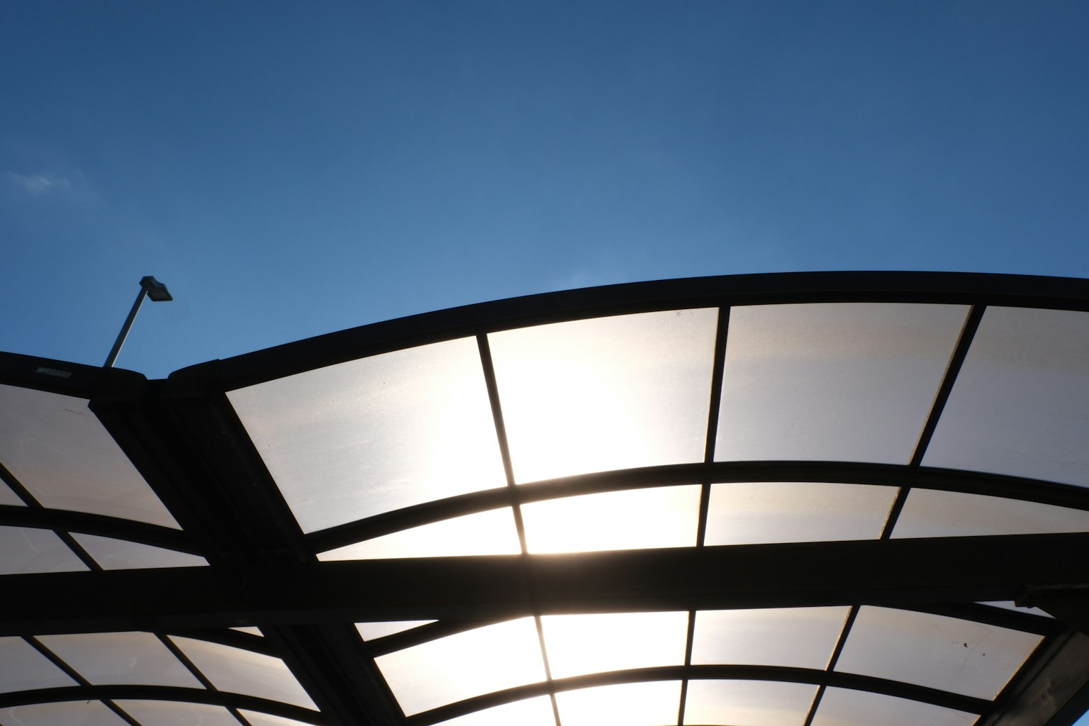 Silhouette of a modern roof structure under a blue sky